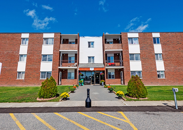 Exterior of an apartment building at 1214 Riverside Drive in Timmins, Ontario.