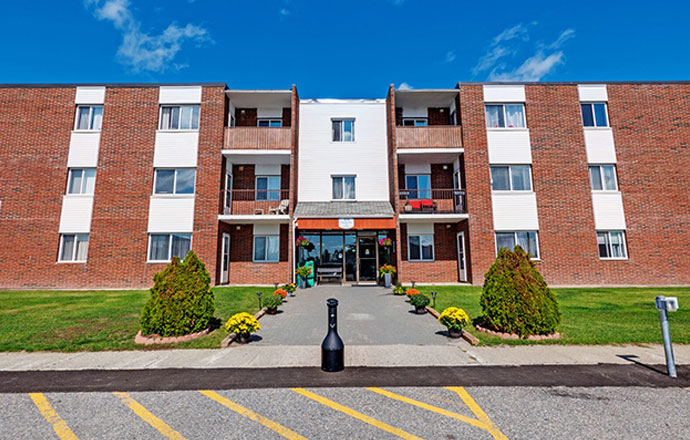 Exterior of an apartment building at 1214 Riverside Drive in Timmins, Ontario.