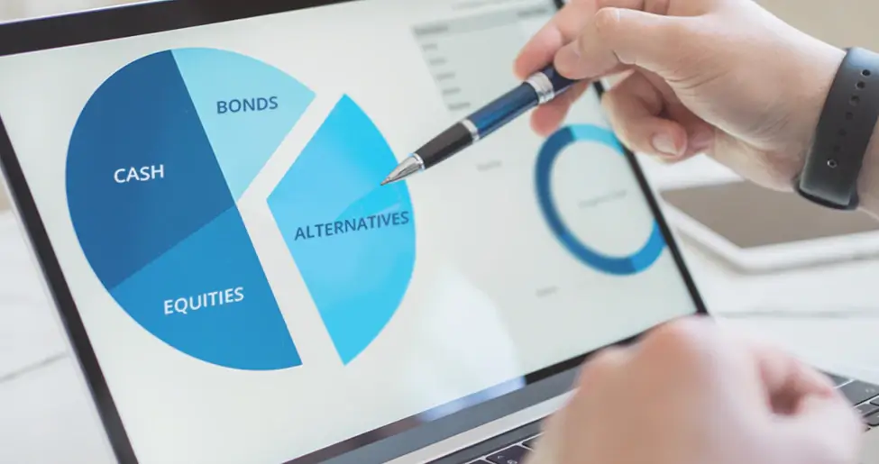 A computer screen showing a chart with a persons hand holding a pen